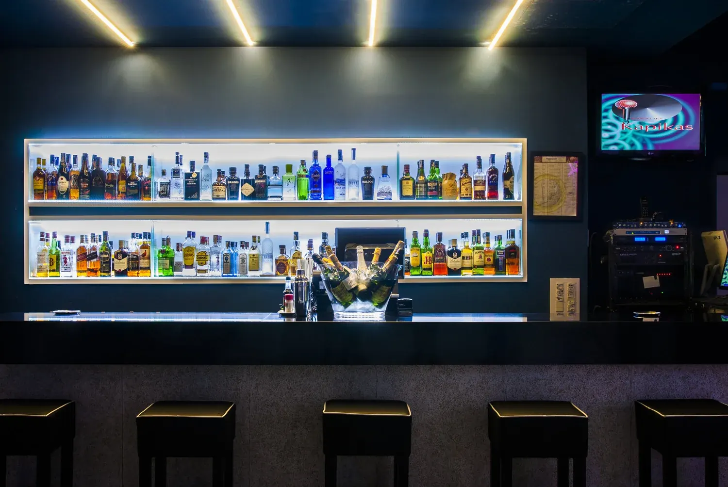 Barra de Kapikas iluminada con botellas