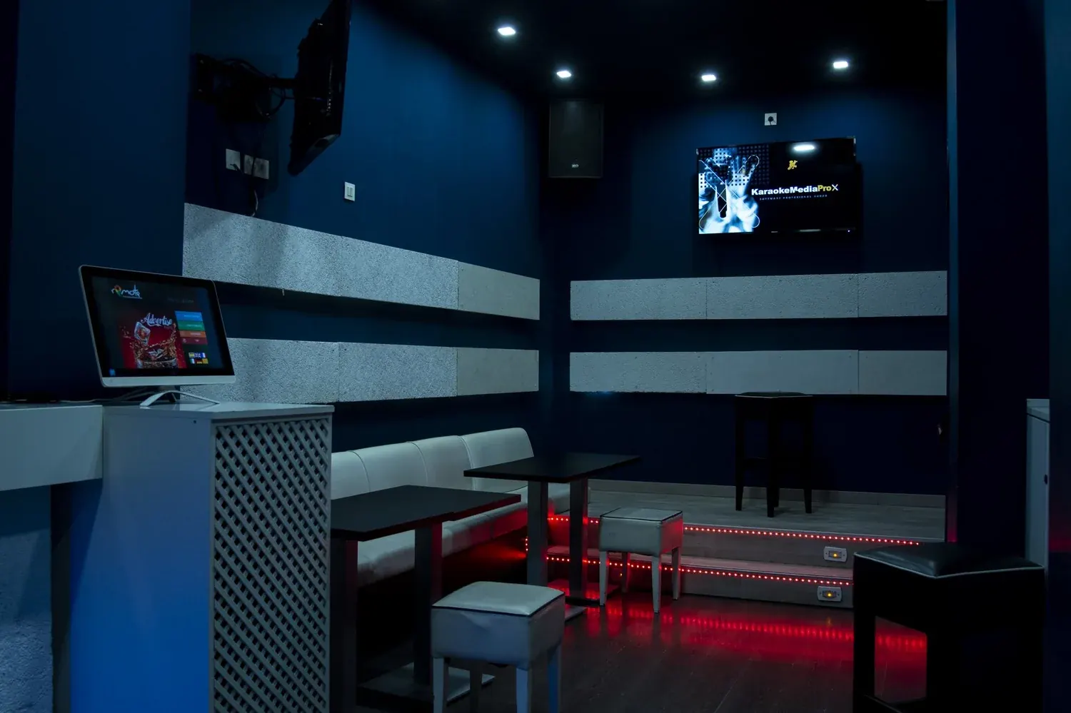 Sala del karaoke con asientos y luces rojas